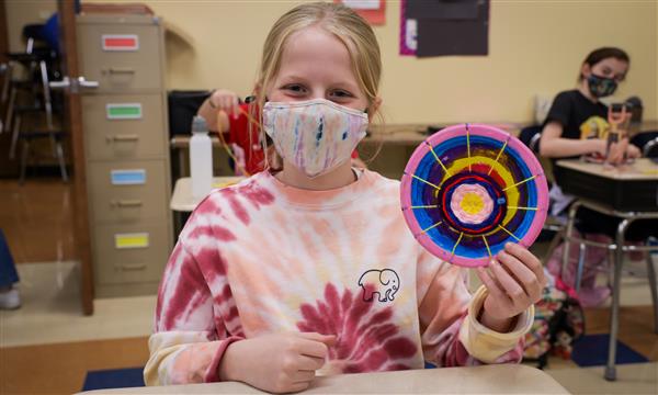 student creates woven craft